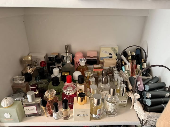 A shelf filled with perfume bottles, sample vials, and travel sprays from Melissa’s collection